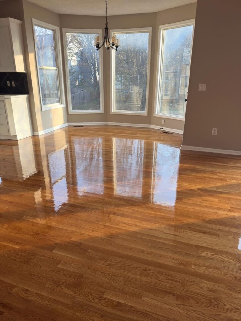 Hardwood Refinish: Glossy natural finish brought back to a bay-window dining room