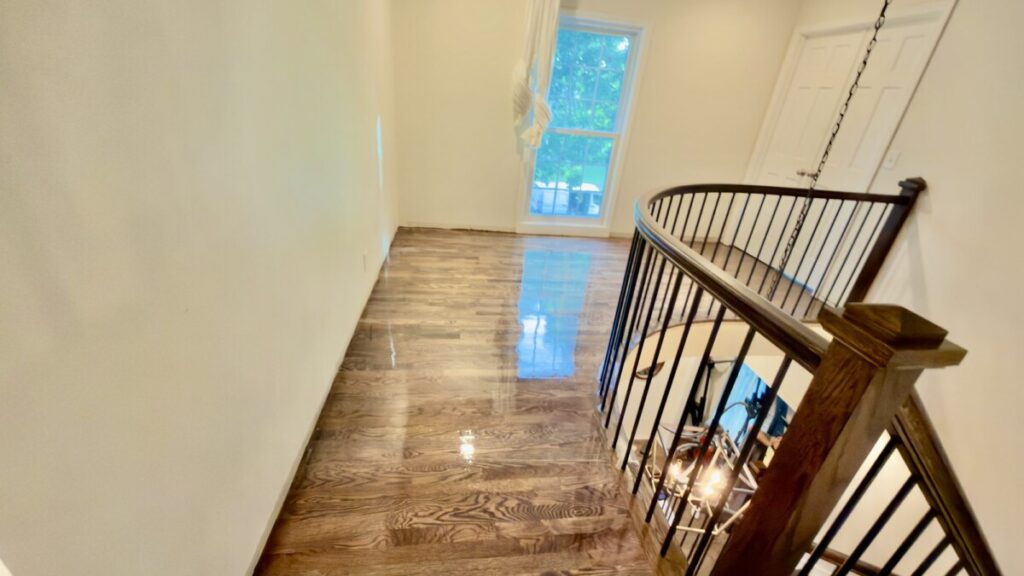 Custom Stairs: Curved stained handrail with iron balusters
