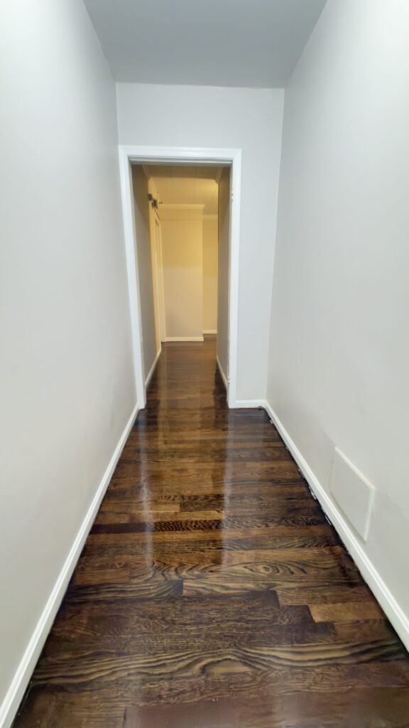 Hallway Refinish: Rich dark stain carried down a long hallway