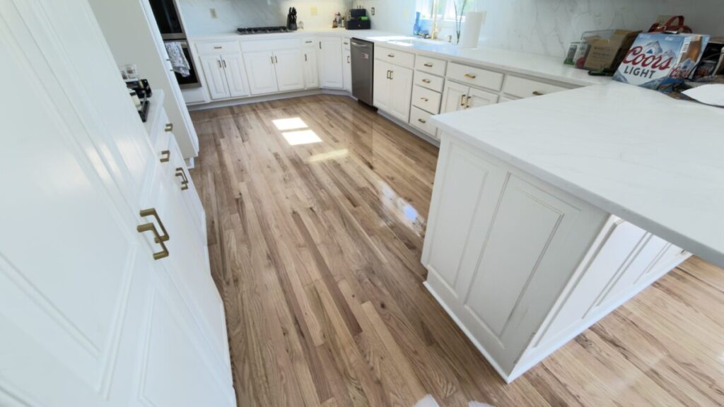 Hardwood Install: Natural hardwood around a white kitchen island